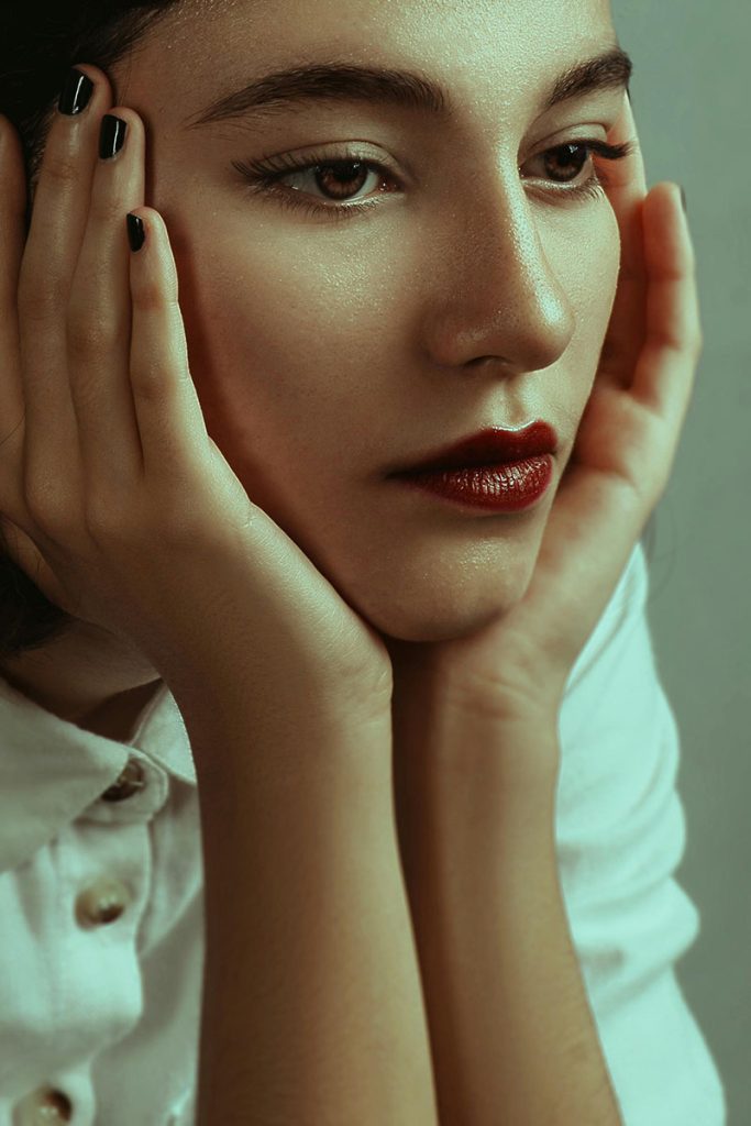 A beautiful woman shows off her strong cheek bones, emulating an ideal midface structure that can be obtained by a cheek implants with Dr. Randall in Morristown, NJ