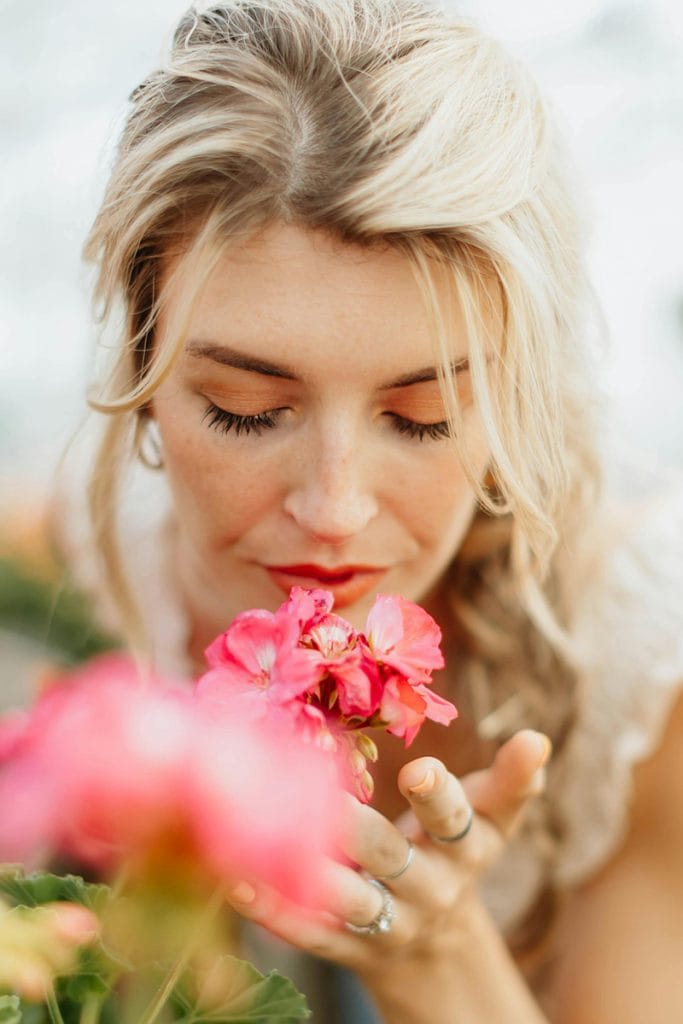A woman is able to smell the flowers- emulating the ideal result from a septoplasty with Dr. Randall in Morristown, NJ